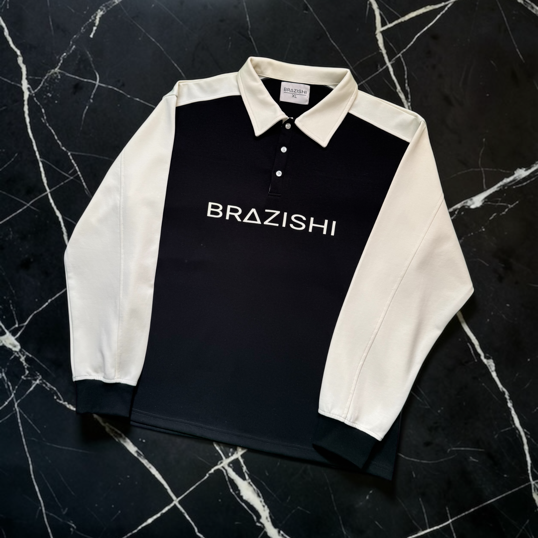 Black and IVORY rugby shirt with 'BRAZISHI' branding on a dark marble background